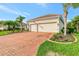 Home exterior with a brick driveway, well-manicured lawn, and an attached two-car garage at 8290 Barton Farms Blvd, Sarasota, FL 34240