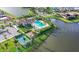 A beautiful aerial view of the pool, tennis court, parking and surrounding lake at 8901 Artisan Way, Sarasota, FL 34240