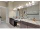 Bathroom featuring granite counters, double vanity sink with view of walk-in closet and glass shower enclosure at 8901 Artisan Way, Sarasota, FL 34240