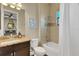 Bright bathroom featuring a granite countertop, tub with shower, and doorway to bedroom at 8901 Artisan Way, Sarasota, FL 34240