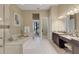 Bright bathroom featuring a soaking tub, a walk-in shower, and a double sink vanity with marble countertops at 8901 Artisan Way, Sarasota, FL 34240
