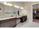 Bathroom featuring granite counters, double vanity sink with view of walk-in closet and glass shower enclosure at 8901 Artisan Way, Sarasota, FL 34240