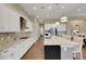 A modern kitchen with white cabinetry, stainless steel appliances, granite countertops, and wood flooring at 8901 Artisan Way, Sarasota, FL 34240