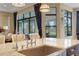 Bright kitchen island with a stainless steel sink, granite countertops, and large windows with seating area in background at 8901 Artisan Way, Sarasota, FL 34240