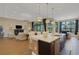 Open-concept living space with large island, pendant lighting, and seamless flow to the living room at 8901 Artisan Way, Sarasota, FL 34240