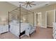 Spacious bedroom featuring a four poster bed, tray ceiling with fan and neutral colored walls at 8901 Artisan Way, Sarasota, FL 34240