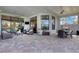 Expansive outdoor patio featuring dining and seating areas, stone pavers, and ceiling fans at 8901 Artisan Way, Sarasota, FL 34240