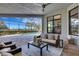 Covered patio features comfortable seating, view of pool, and tropical landscaping at 8901 Artisan Way, Sarasota, FL 34240