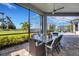 Screened-in patio features dining set, view of backyard, pool, and palm trees at 8901 Artisan Way, Sarasota, FL 34240