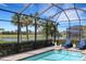 Screened-in pool with brick trim and lovely lake views and two lounge chairs at 8901 Artisan Way, Sarasota, FL 34240