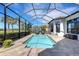 Screened-in pool with lounge chairs and view of lush landscaping at 8901 Artisan Way, Sarasota, FL 34240