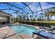 Covered lanai with pool, lounge chairs, and lush landscaping at 8901 Artisan Way, Sarasota, FL 34240