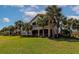 Backyard view of a multi-story house with a screened in porch, balcony and palm trees at 9415 Discovery Ter # 101A, Bradenton, FL 34212