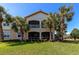 Exterior shot of the property, featuring a well-maintained lawn and mature palm trees at 9415 Discovery Ter # 101A, Bradenton, FL 34212