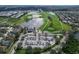 An aerial view of a golf course, clubhouse, and parking lot surrounded by residential homes and roads at 1113 Cane Mill Ln, Bradenton, FL 34212