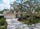 Charming exterior of home with a 2-car garage, mature landscaping, and a lovely front yard at 1113 Cane Mill Ln, Bradenton, FL 34212