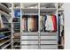 Large walk-in closet with white built-in shelving, closet rods and drawers for optimal storage organization at 115 E Saint Lucia Loop, Apollo Beach, FL 33572