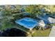 Aerial view of community pool and patio area with lounge chairs and umbrellas amidst lush greenery at 1153 Edgewater Cir, Bradenton, FL 34209
