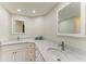 Bathroom with dual sinks, white cabinets, and modern countertops at 1153 Edgewater Cir, Bradenton, FL 34209