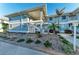 Two-story condo building featuring coastal blue siding, white accents, and lush landscaping at 1153 Edgewater Cir, Bradenton, FL 34209