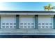 Three white garages with lattice details line the driveway, providing convenient parking and storage at 1153 Edgewater Cir, Bradenton, FL 34209