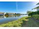 A tranquil pond lined with lush green grass and mature trees, reflecting the clear blue sky at 1153 Edgewater Cir, Bradenton, FL 34209