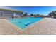 Community pool with clear blue water, brick pavers, and lounge seating surrounded by a white fence and lush landscaping at 1153 Edgewater Cir, Bradenton, FL 34209