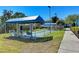 Recreational shuffleboard courts under shading with nearby benches, mature landscaping, and paved sidewalk at 1153 Edgewater Cir, Bradenton, FL 34209