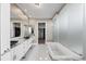 Bathroom featuring double vanity, marble countertop, and soaking tub at 1155 N Gulfstream Ave # 1709, Sarasota, FL 34236