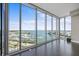 A sun-filled living room with sleek wood flooring, large windows, and an expansive view of the water and city at 1155 N Gulfstream Ave # 1709, Sarasota, FL 34236