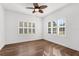 Inviting bedroom featuring hardwood flooring, two large windows and a ceiling fan, offering natural light and comfort at 11603 Gramercy Park Ave, Bradenton, FL 34211