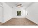 This bedroom features neutral carpet, white walls, a ceiling fan, and a window with blinds at 11603 Gramercy Park Ave, Bradenton, FL 34211