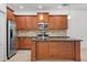 Beautiful kitchen featuring stainless steel appliances, dark wood cabinets, granite counter tops, and an island at 11603 Gramercy Park Ave, Bradenton, FL 34211