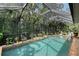 Screened in pool and patio surrounded by lush tropical landscaping at 1188 Tahiti Pkwy, Sarasota, FL 34236