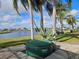 Backyard with a SaluSpa hot tub overlooking a scenic lake view, surrounded by palm trees at 1211 Peridot Lane, Sun City Center, FL 33573