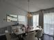 Bright dining room featuring a dining table with chandelier, dark floors, and paintings at 1211 Peridot Lane, Sun City Center, FL 33573