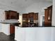 Spacious kitchen with dark brown cabinets, black countertops, stainless steel appliances and bar seating at 1211 Peridot Lane, Sun City Center, FL 33573