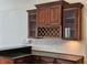 Kitchen features dark wood cabinetry, granite countertops, wine rack, and glass-fronted cabinets at 1211 Peridot Lane, Sun City Center, FL 33573