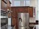 Modern kitchen with stainless steel refrigerator, dark wood cabinets and granite countertops at 1211 Peridot Lane, Sun City Center, FL 33573