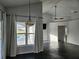 Bright living room with dark floors, view to the pool, vaulted ceilings, and modern fixtures at 1211 Peridot Lane, Sun City Center, FL 33573