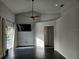 Bright living room with sleek black floors, vaulted ceilings, TV, and sliding doors to the pool at 1211 Peridot Lane, Sun City Center, FL 33573