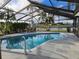 Inviting screened in pool area offers a serene view of the adjacent lake at 1211 Peridot Lane, Sun City Center, FL 33573