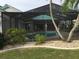 This property's in-ground pool is surrounded by a screened enclosure and beautiful landscaping at 1211 Peridot Lane, Sun City Center, FL 33573