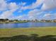Breathtaking view of the lake and surrounding community with lush green lawn in the foreground at 1211 Peridot Lane, Sun City Center, FL 33573