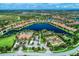 Aerial view of a community with a lake, community pool, tennis courts, and lush landscaping at 13214 Treviso Dr, Bradenton, FL 34211