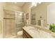Well-lit bathroom with granite vanity, shower, and decorative tile accents at 13214 Treviso Dr, Bradenton, FL 34211