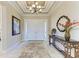 Bright foyer featuring tile floors, a decorative mirror, and a console table with floral accents at 13214 Treviso Dr, Bradenton, FL 34211
