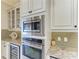 Modern kitchen with stainless steel microwave and oven, complemented by granite countertops at 13214 Treviso Dr, Bradenton, FL 34211