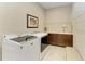 Functional laundry room features front loading washer/dryer, tile floor, built-in sink, and cabinet storage at 13214 Treviso Dr, Bradenton, FL 34211