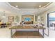 Open-concept living room with neutral tones, tray ceiling, and elegant decor throughout the space at 13214 Treviso Dr, Bradenton, FL 34211
